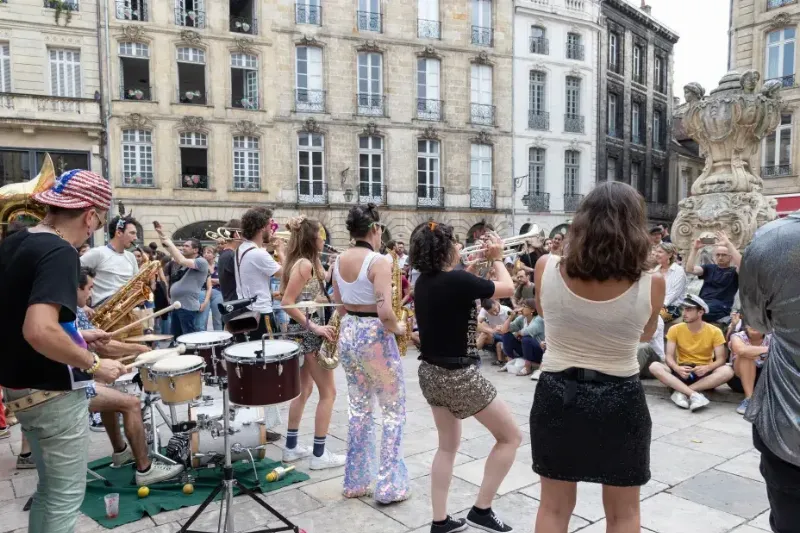 Artistes de rue et public profitant de la Fete de la Musique dans une ville francaise animee